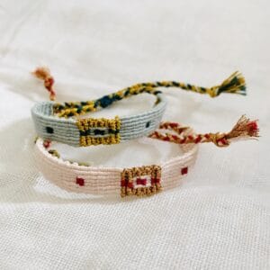 Duo de bracelets type « brésilien » tissé main, en fil de coton rose ou vert et fil métallisé doré. Motifs rectangle et points.