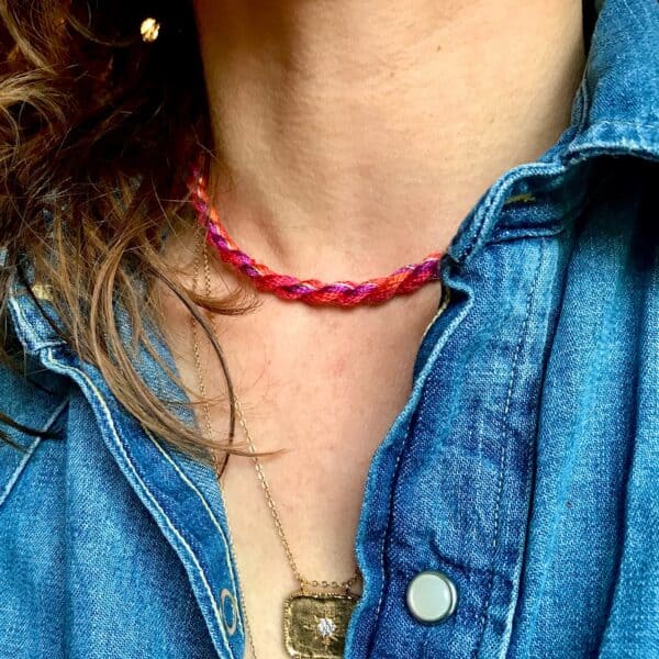 collier cordon torsadé ras de cou, en soie et fil métallisé doré, dans les tons violet, rose, rouge et orange, porté sans pendentif