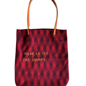 sac cabas brodé, en tissu ikat rouge et prune, avec anses en cuir fauve, sur fond blanc