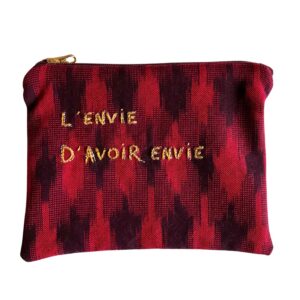 petite pochette brodée main, en tissu ikat rouge et prune, avec fermeture zippée prune et curseur doré, sur fond blanc