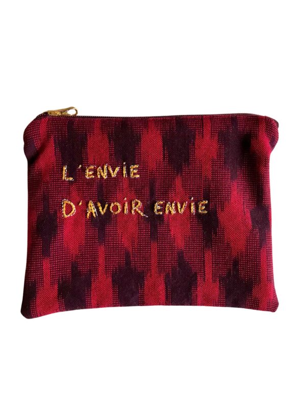 petite pochette brodée main, en tissu ikat rouge et prune, avec fermeture zippée prune et curseur doré, sur fond blanc